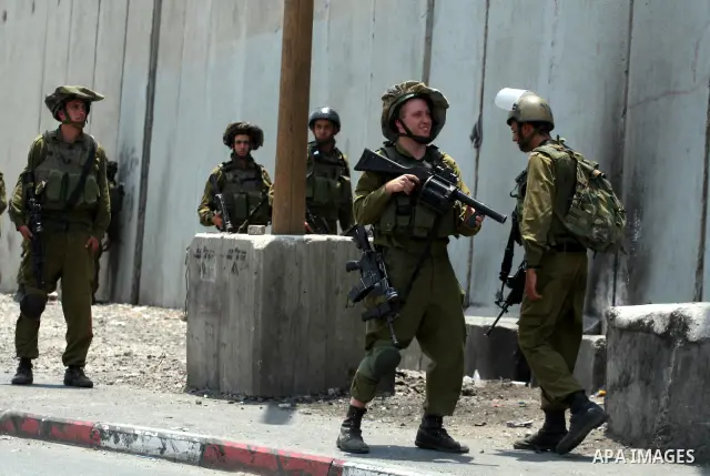 Israeli security forces take position during clashes with locally-based Palestinian demonstrators, not pictured, at the Qalandia checkpoint between the West Bank city of Ramallah and Jerusalem, Saturday, July 9, 2011. Is...