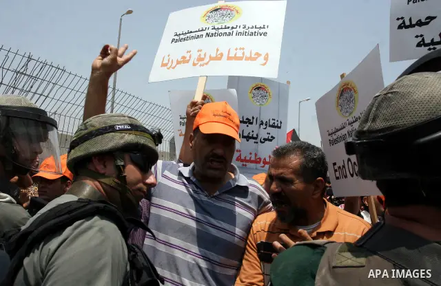 Israeli security forces scuffle with locally-based Palestinian demonstrators during clashes at the Qalandia checkpoint between the West Bank city of Ramallah and Jerusalem, Saturday, July 9, 2011. Israel's interior minis...