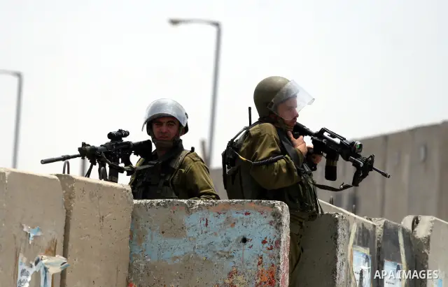 Israeli security forces take position during clashes with locally-based Palestinian demonstrators, not pictured, at the Qalandia checkpoint between the West Bank city of Ramallah and Jerusalem, Saturday, July 9, 2011. Is...