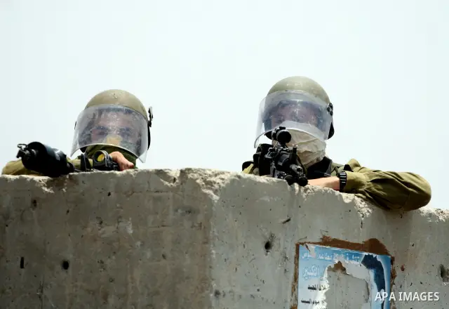Israeli security forces take position during clashes with locally-based Palestinian demonstrators, not pictured, at the Qalandia checkpoint between the West Bank city of Ramallah and Jerusalem, Saturday, July 9, 2011. Is...