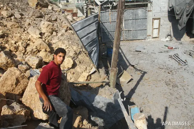 A Palestinian man inspects amid the ruins of a building bombed by Israeli aircraft in the east of Gaza City on July 10, 2011. Photo by Ashraf Amra
