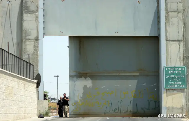 Israeli soldiers stand guard as Palestinians and foreigners protest in front of a section of Israel's controversial separation barrier at the main entrance of the West Bank city of Bethlehem on July 10, 2011, marking the...