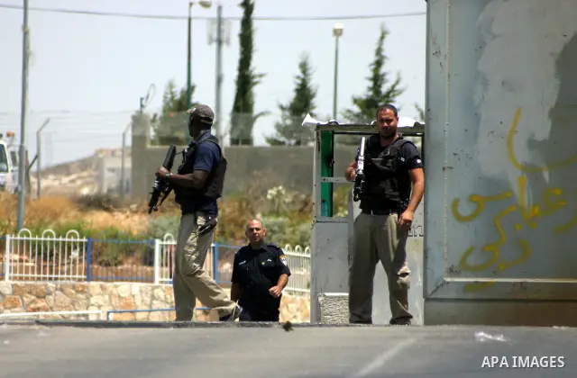 Israeli soldiers stand guard as Palestinians and foreigners protest in front of a section of Israel's controversial separation barrier at the main entrance of the West Bank city of Bethlehem on July 10, 2011, marking the...