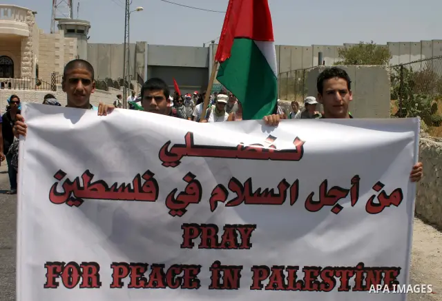 Israeli soldiers stand guard as Palestinians and foreigners protest in front of a section of Israel's controversial separation barrier at the main entrance of the West Bank city of Bethlehem on July 10, 2011, marking the...