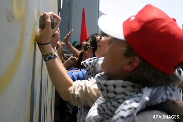 Palestinians and foreigners protest in front of a section of Israel's controversial separation barrier at the main entrance of the West Bank city of Bethlehem on July 10, 2011, marking the seventh anniversary of a ruling...