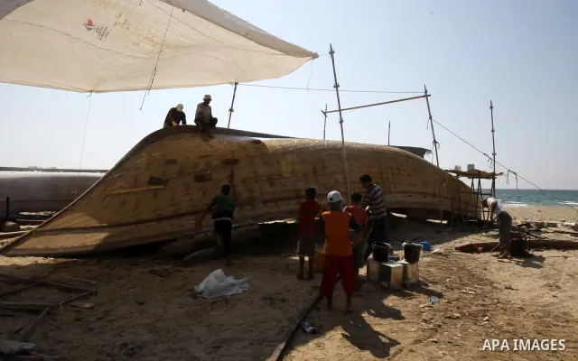Palestinian fishermen repair their boat on Gaza city beach on July 10,2011. Photo by Mahmoud Nassar