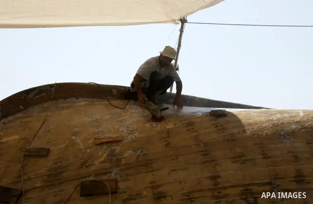Palestinian fishermen repair their boat on Gaza city beach on July 10,2011. Photo by Mahmoud Nassar