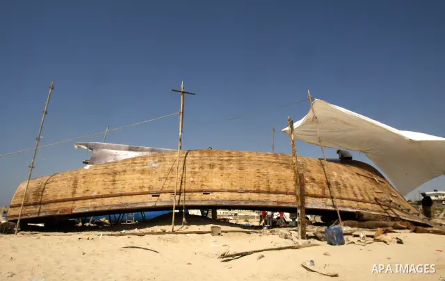 Palestinian fishermen repair their boat on Gaza city beach on July 10,2011. Photo by Mahmoud Nassar