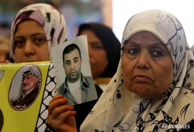 Relatives of Palestinian prisoners attend a march organized by the Red Cross calling Israel to allow residents of Gaza to visit their relatives imprisoned in Israel, on July 11, 2011 in Gaza City. Israel stopped allowing...