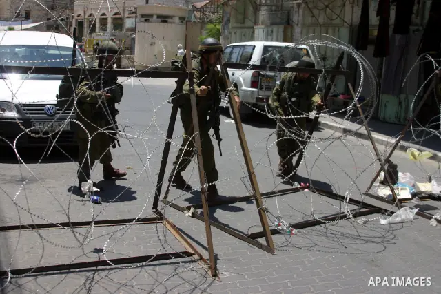 Israeli soldiers stop Palestinian and International activists who attempt to demonstrate against the closure of Shuhada Street in Hebron,a main artery blocked by an Israeli military checkpoint in the center of the West B...