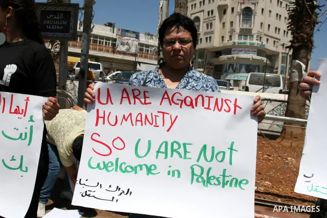 Palestinians hold signs against the visit by Greek President Karolos Papoulias to the West Bank during a protest in Ramallah on July 12, 2011. Papoulias met Palestinian Authority President Mahumud Abbas today in the West...