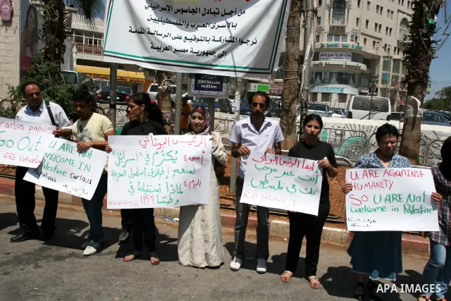Palestinians hold signs against the visit by Greek President Karolos Papoulias to the West Bank during a protest in Ramallah on July 12, 2011. Papoulias met Palestinian Authority President Mahumud Abbas today in the West...