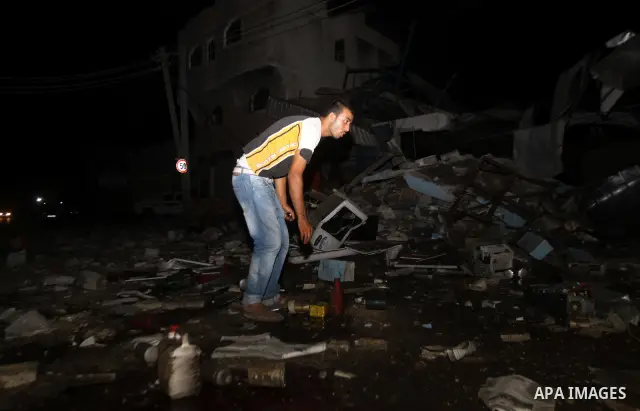 A Palestinian man inspects debris in a destroyed car wash garage after Israeli airstrike in the Al Tuffah area in the east of Gaza City, in the Gaza Strip on 12 July 2011.. Photo by Ali Jadallh