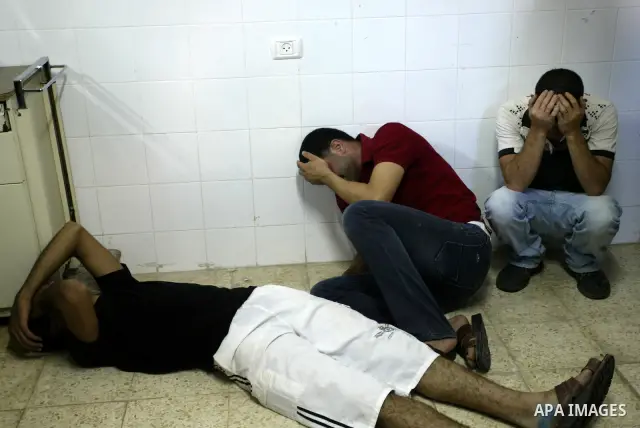 Palestinian relatives at the morgue in the West Bank city of Nablus mourn the death of 21 year-old Ibrahim Sarhan, who was shot dead during an Israeli raid on the refugee camp Al-Fara, north of Nablus on July 13, 2011. P...