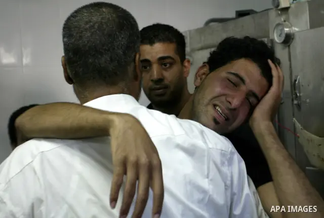 Friends and relatives of Palestinian Ibrahim Sarhan, killed by Israeli military, react in the morgue in the Rafidiya Hospital in the West Bank city of Nablus, Wednesday, July 13, 2011. Sarhan was killed Wednesday in an I...