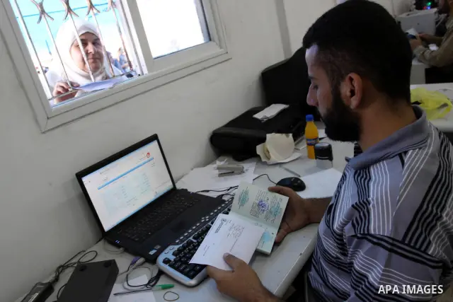 Palestinians wait behind the window to register their names with the Ministry of the Interior in the lists of travel in Gaza city on July 13, 2011. Where there are more than 20 thousand citizens need to travel abroad, Th...