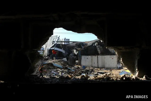 Palestinians inspect the site of an early morning Israeli airstrike in the al-Tuffah area, eastern Gaza City , which left one person wounded, on July 13, 2011, after Palestinians fired three rockets into southern Israel...
