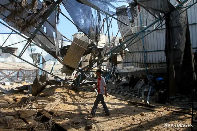 Palestinians inspect the site of an early morning Israeli airstrike in the al-Tuffah area, eastern Gaza City , which left one person wounded, on July 13, 2011, after Palestinians fired three rockets into southern Israel...