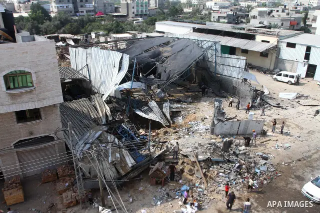 Palestinians inspect the site of an early morning Israeli airstrike in the al-Tuffah area, eastern Gaza City , which left one person wounded, on July 13, 2011, after Palestinians fired three rockets into southern Israel...
