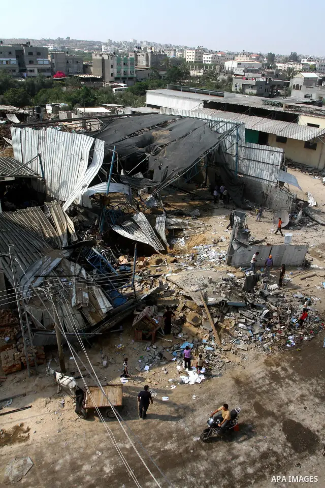 Palestinians inspect the site of an early morning Israeli airstrike in the al-Tuffah area, eastern Gaza City , which left one person wounded, on July 13, 2011, after Palestinians fired three rockets into southern Israel...