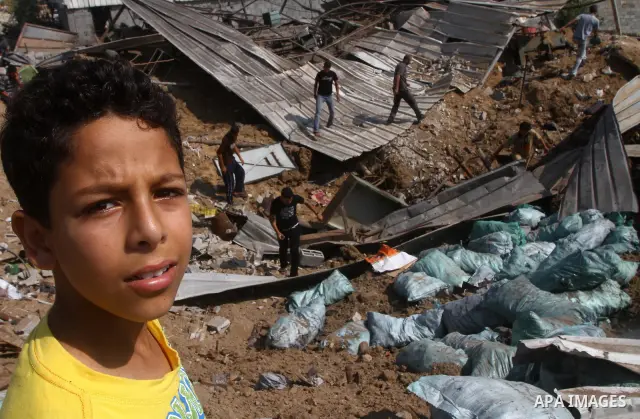 Palestinians inspect the site of an early morning Israeli airstrike in the al-Tuffah area, eastern Gaza City , which left one person wounded, on July 13, 2011, after Palestinians fired three rockets into southern Israel...