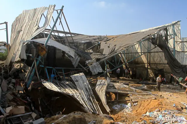 Palestinians inspect the site of an early morning Israeli airstrike in the al-Tuffah area, eastern Gaza City , which left one person wounded, on July 13, 2011, after Palestinians fired three rockets into southern Israel...