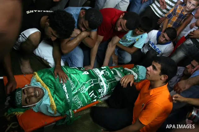 Palestinian mourners gather around the body of Ibrahim Sarhan, killed by Israeli military, during his funeral in the West Bank refugee camp of El Fara, north of Nablus, Wednesday, July 13, 2011. Sarhan was killed Wednesd...
