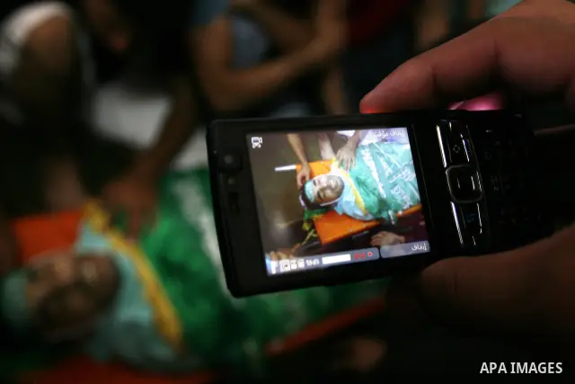 Palestinian mourners gather around the body of Ibrahim Sarhan, killed by Israeli military, during his funeral in the West Bank refugee camp of El Fara, north of Nablus, Wednesday, July 13, 2011. Sarhan was killed Wednesd...