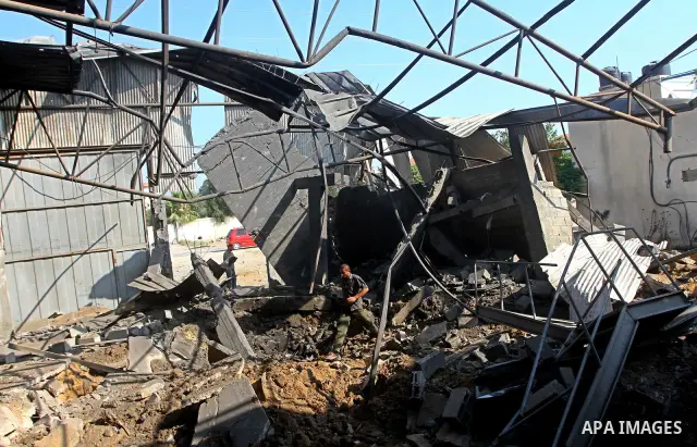 Palestinians inspect the rubble of a metal workshop after an Israeli air strike in Gaza city, early Thursday, July 14, 2011. Photo by Ashraf Amra