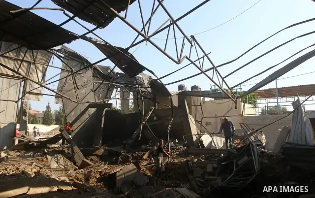 Palestinians inspect the rubble of a metal workshop after an Israeli air strike in Gaza city, early Thursday, July 14, 2011. Photo by Ashraf Amra