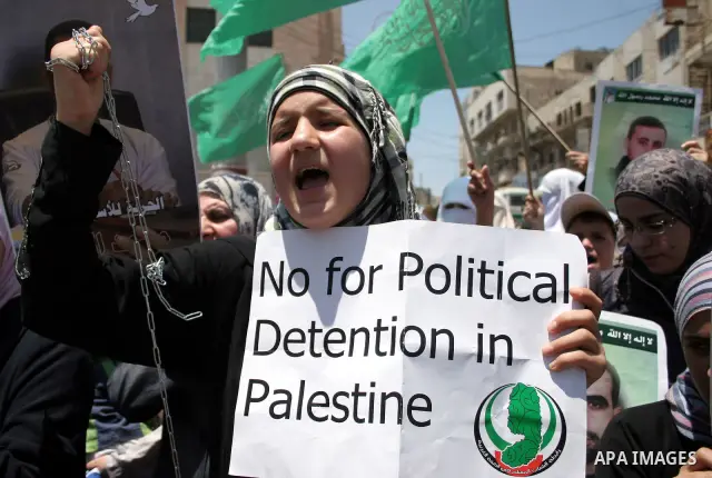 Hamas members of the Palestinian Legislative Council (PLC) take part with Palestinian supporters of the Hamas Islamist movement during a rally calling for the release of Palestinians being held in West Bank and Gaza Stri...