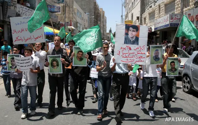 Hamas members of the Palestinian Legislative Council (PLC) take part with Palestinian supporters of the Hamas Islamist movement during a rally calling for the release of Palestinians being held in West Bank and Gaza Stri...