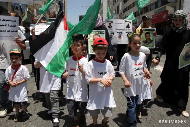 Hamas members of the Palestinian Legislative Council (PLC) take part with Palestinian supporters of the Hamas Islamist movement during a rally calling for the release of Palestinians being held in West Bank and Gaza Stri...
