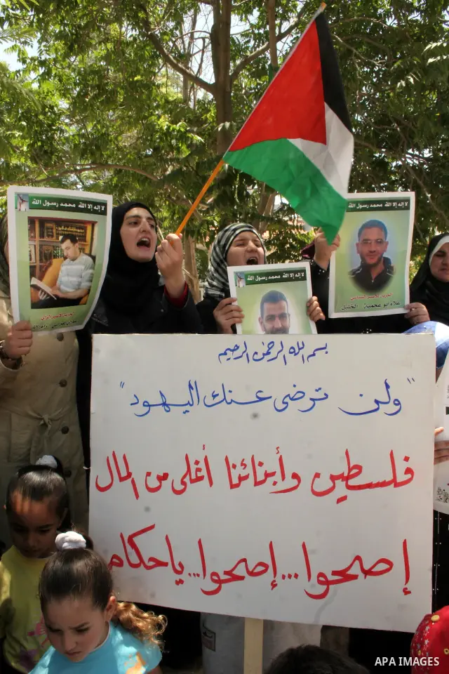 Hamas members of the Palestinian Legislative Council (PLC) take part with Palestinian supporters of the Hamas Islamist movement during a rally calling for the release of Palestinians being held in West Bank and Gaza Stri...