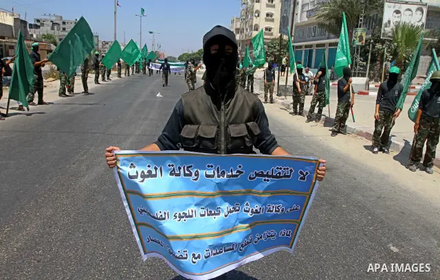 Masked Palestinians from Hamas participate in a protest calling for the release of Palestinian prisoners held in Israel and against the UNESCO decision to consider Jerusalem capital of Israel, at the Nusseirat refugee ca...