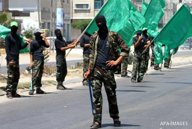 Masked Palestinians from Hamas participate in a protest calling for the release of Palestinian prisoners held in Israel and against the UNESCO decision to consider Jerusalem capital of Israel, at the Nusseirat refugee ca...