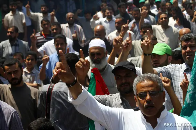 Palestinians Hamas supporters participate in a protest calling for the release of Palestinian prisoners held in Israel and against the UNESCO decision to consider Jerusalem capital of Israel, at the Nusseirat refugee cam...