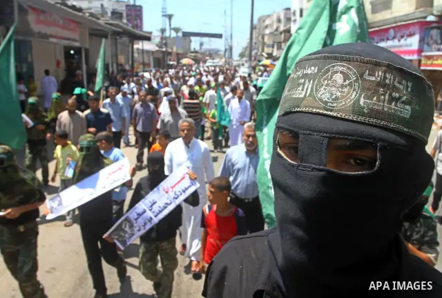 Masked Palestinians from Hamas participate in a protest calling for the release of Palestinian prisoners held in Israel and against the UNESCO decision to consider Jerusalem capital of Israel, at the Nusseirat refugee ca...