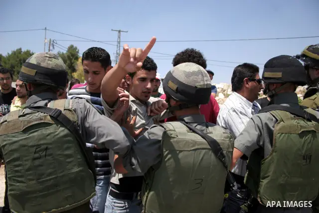 Protesters argue with an Israeli soldiers during a demonstration against Israel's controversial separation barrier in the West Bank village of Maasarah, near the biblical town of Bethlehem on 15 July 2011. Israel says th...