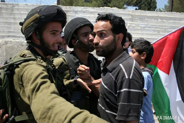 Protesters argue with an Israeli soldiers during a demonstration against Israel's controversial separation barrier in the West Bank village of Maasarah, near the biblical town of Bethlehem on 15 July 2011. Israel says th...