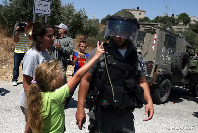 A Palestinian child argues with an Israeli soldier during clashes with protesters following a demonstration against Israeli occupation and settlements expansion, on July 15, 2011 in the West Bank village of Nabi Saleh Ph...
