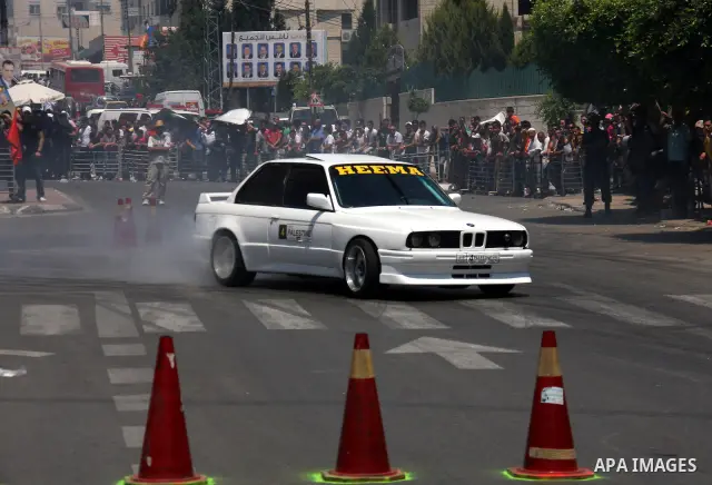 Palestinians watch cars race during the Palestinian National Racing Championship in the West Bank city of Nablus, Friday,July 15, 2011. Photo by Wagdi Eshtayah