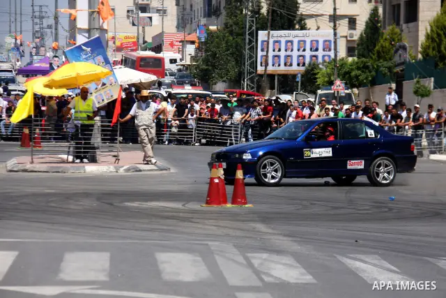Palestinians watch cars race during the Palestinian National Racing Championship in the West Bank city of Nablus, Friday,July 15, 2011. Photo by Wagdi Eshtayah