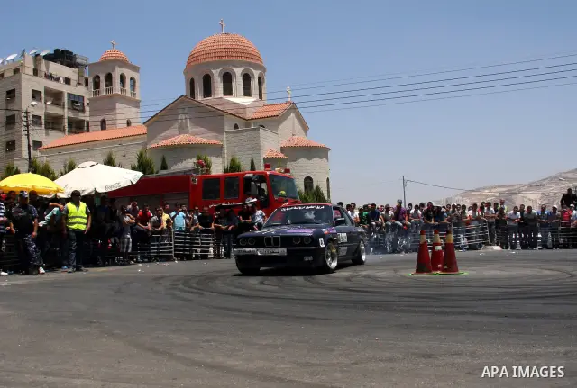 Palestinians watch cars race during the Palestinian National Racing Championship in the West Bank city of Nablus, Friday,July 15, 2011. Photo by Wagdi Eshtayah
