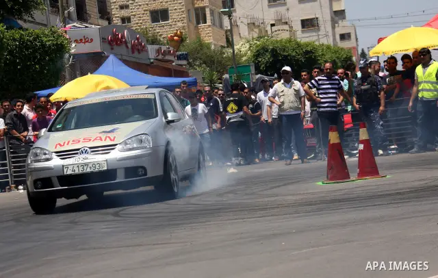 Palestinians watch cars race during the Palestinian National Racing Championship in the West Bank city of Nablus, Friday,July 15, 2011. Photo by Wagdi Eshtayah