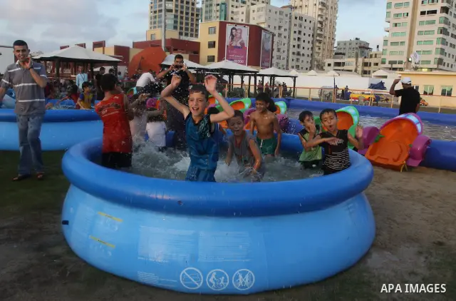 Palestinian children play in a swimming pool at a park in Gaza City on July 15, 2011. Phot by Naaman Omar