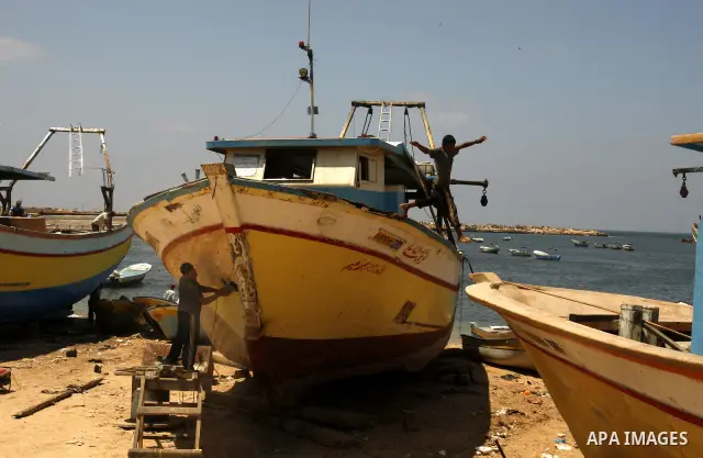 Palestinian fishermen prepare their boats for fishing at Gaza beach on July 16,2011. Photo by Mahmoud Nassar