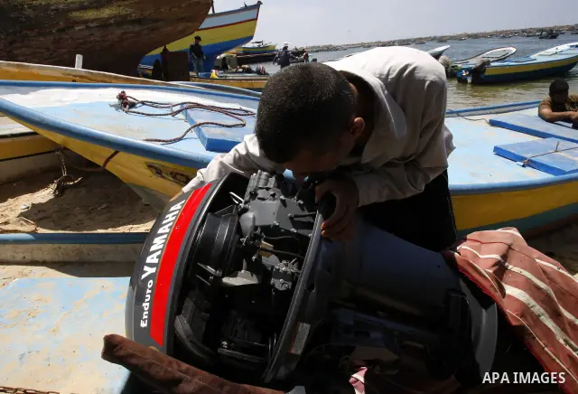 A Palestinian fisherman inspects his boat after it was damaged by Israeli Naval, at Gaza beach on July 16,2011. Photo by Mahmoud Nassar