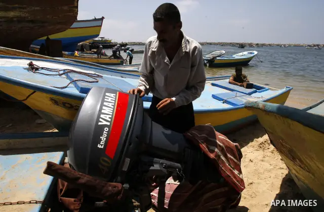 A Palestinian fisherman inspects his boat after it was damaged by Israeli Naval, at Gaza beach on July 16,2011. Photo by Mahmoud Nassar