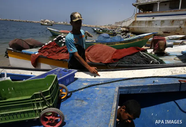 A Palestinian fisherman inspects his boat after it was damaged by Israeli Naval, at Gaza beach on July 16,2011. Photo by Mahmoud Nassar